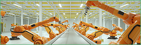 je ziet een fabriek van binnen, veel oranje machines staan langs een transportband die niet in werking is